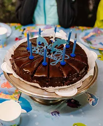 Schokoladentorte mit Geburtstagskerzen bei einer Feier in der Fossilienwelt.
