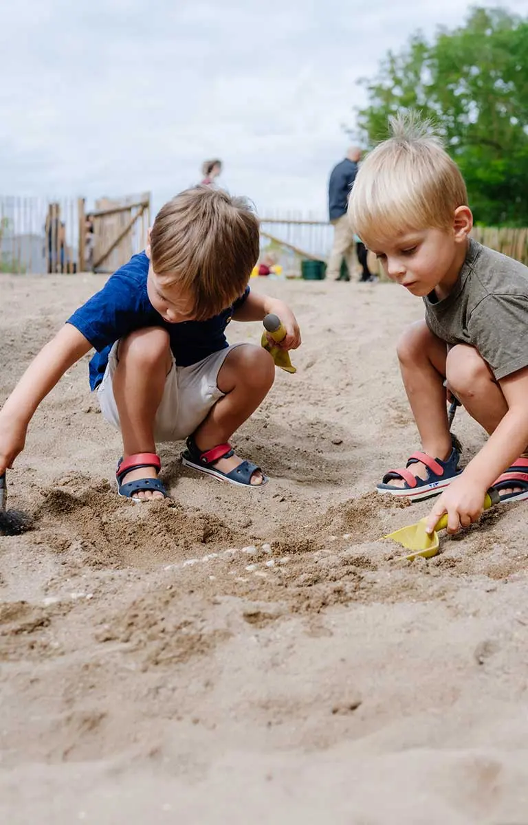 Kinder graben im Sand nach Fossilien in der Fossilienwelt.